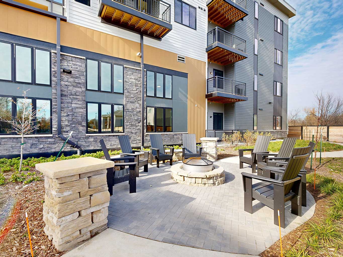 Exterior of Aura Independent Living featuring fire pit and circular sitting area.