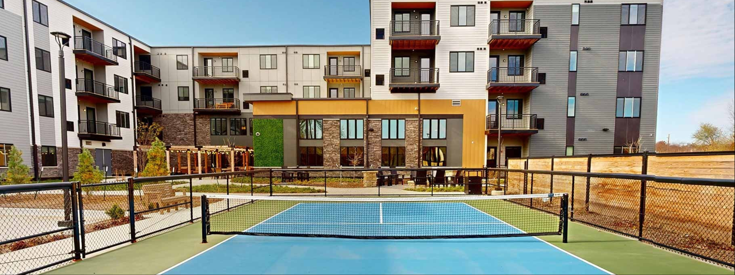 Exterior shot of Aura Independent Living featuring pickleball court.