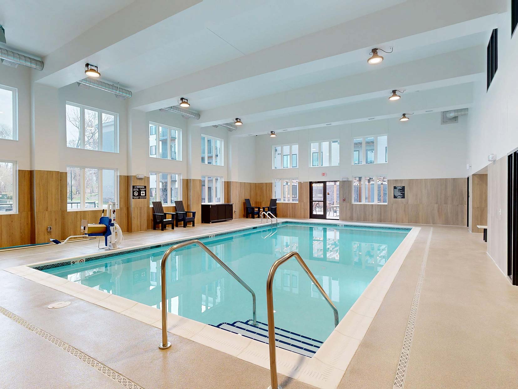 The pool at Aura Independent Living, featuring clear blue water and bright, open indoor location with lots of natural light.