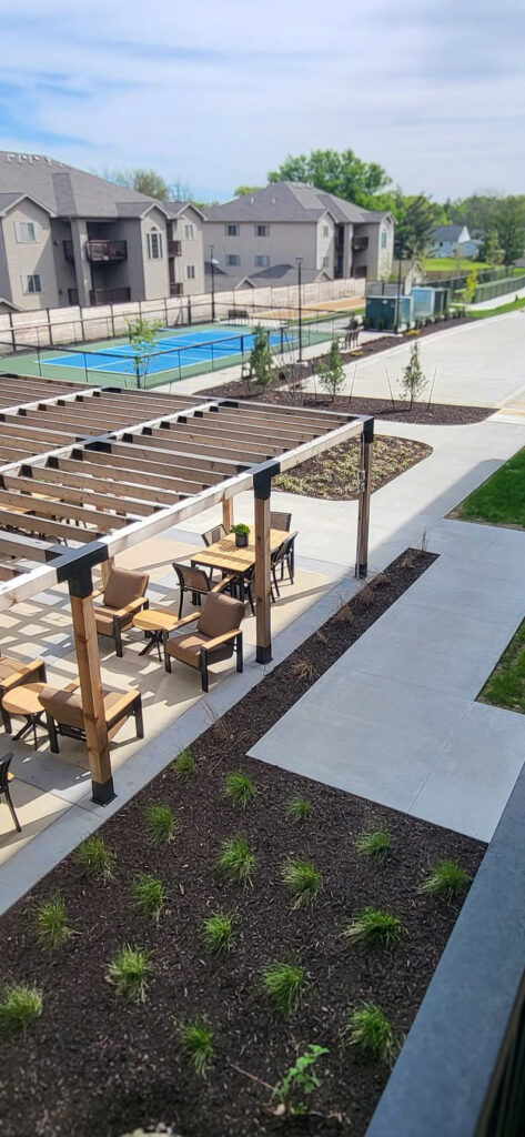 Freshly planted grounds at Aura Independent Living, enriching outdoor areas including sitting spaces and pickleball court.